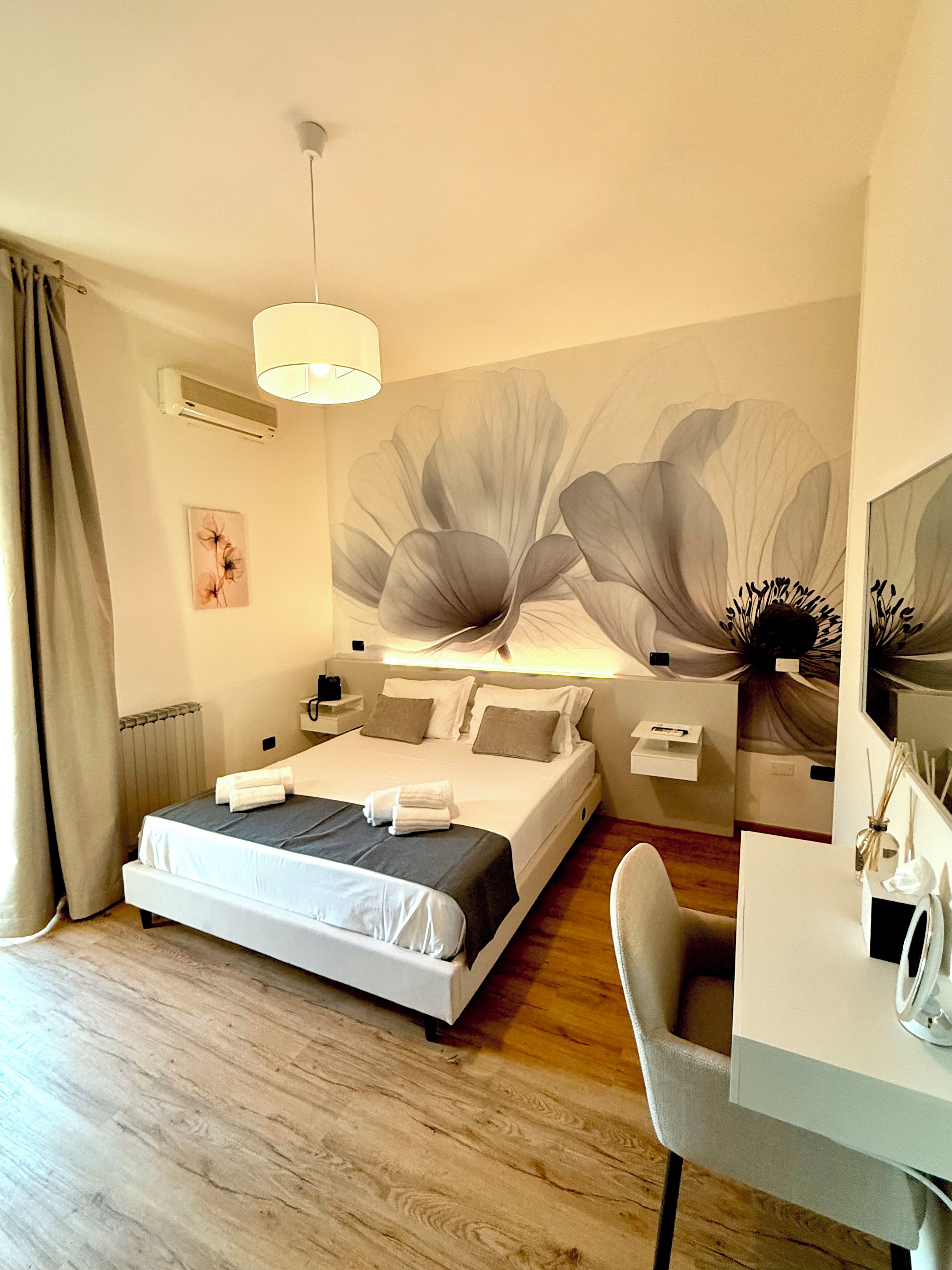 Una habitación de hotel moderna con una cama grande, un escritorio y un mural en la pared.