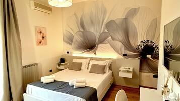 Una habitación de hotel moderna con una cama grande, un escritorio y un mural en la pared.