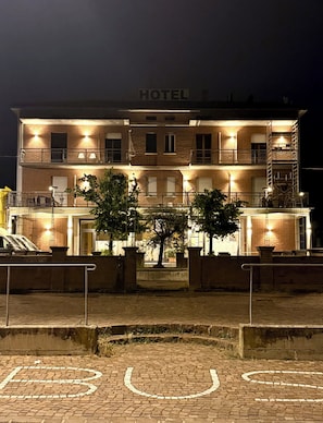 Ein Hotel mit Schilder, mehreren Balkonen und einer Ziegelaußenwand.