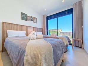 Ein Hotelzimmer mit zwei Betten, einem großen Fenster mit Aussicht und einem kleinen Hocker.