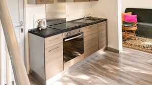 A modern kitchen with wooden cabinets, a black countertop, and a stainless steel range hood. - Quiet house in Seignosse. Enclosed patio and parking  (Seignosse)