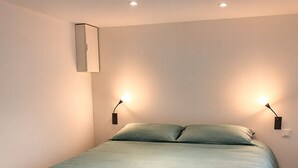 A bed with a green bedspread, two bedside lamps, and a wall-mounted light fixture. - Quiet house in Seignosse. Enclosed patio and parking  (Seignosse)