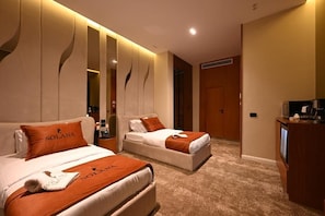 Una habitación de hotel con dos camas, televisión y minibar.