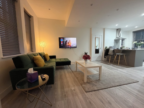 A modern living room with a sofa, coffee table, and TV.