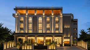 A multi-story hotel with a grand entrance, large windows, and a well-lit facade.