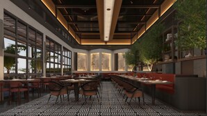 A modern restaurant interior with high ceilings, large windows, and a patterned floor.