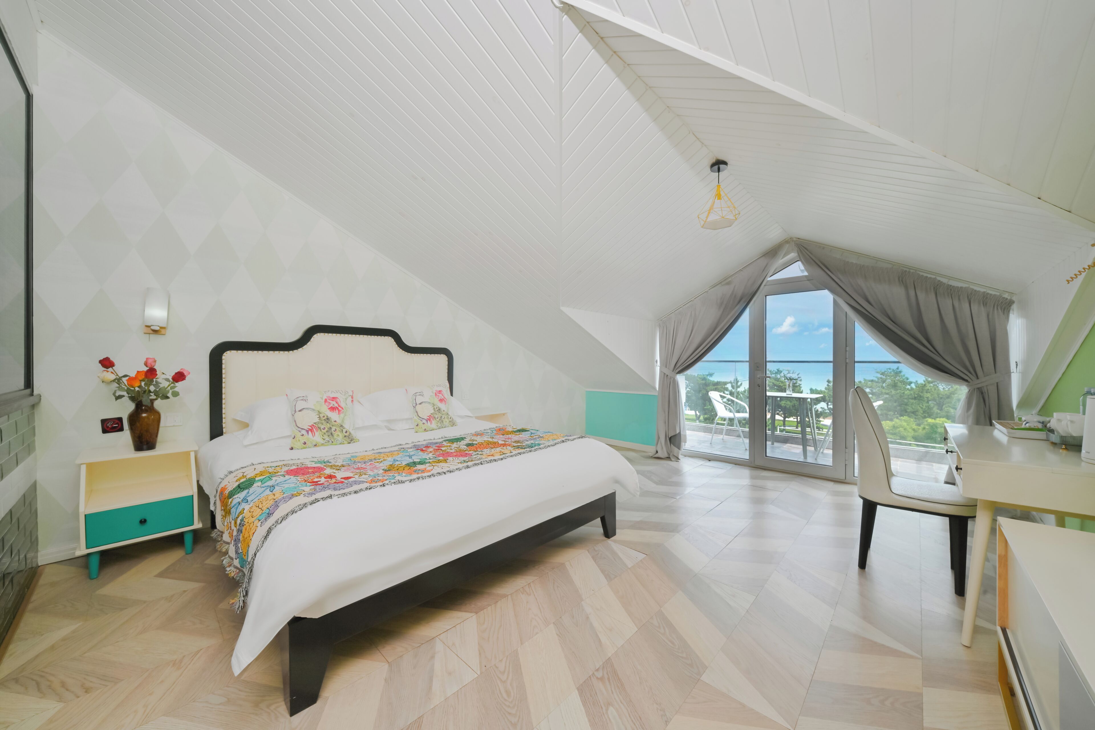 Un dormitorio con cama, escritorio, silla, ventana y vistas al exterior.