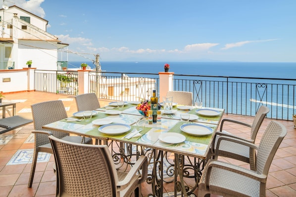 Eine Terrasse mit Essplatz, mit Blick auf ein Gewässer.