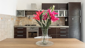 A kitchen with dark cabinets, a microwave, and a gas stove. - Casa Centotrecento by Wonderful Italy (Bologna)