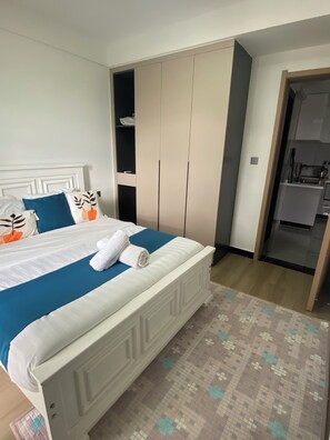Ein Hotelzimmer mit Bett, Kleiderschrank, Badezimmer und Küchenzeile.