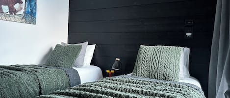 A room with a bed, a nightstand, a lamp, and a painting on the wall.