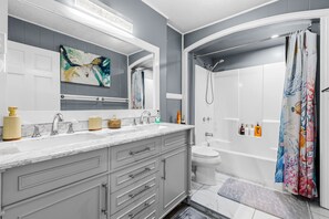 Ein modernes Badezimmer mit einem Doppelwaschtisch, einer Dusche und einer Toilette.