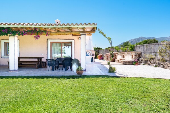 Ein Haus mit Terrasse, Gartenmöbeln und Bergblick.