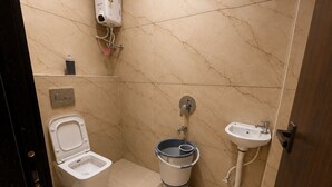 Un baño pequeño con inodoro, bidé y lavamanos.