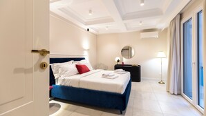 Ein Hotelzimmer mit Bett, Nachttisch, Lampe, Spiegel und Blick ins Freie.