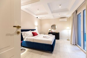 Une chambre d’hôtel avec un lit, une table de chevet, une lampe, un miroir et une vue sur l’extérieur.