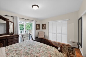 A bedroom with a bed, dresser, chair, and a window with blinds. - Family-Friendly Aloha Home Near Intel & Nike (Aloha)