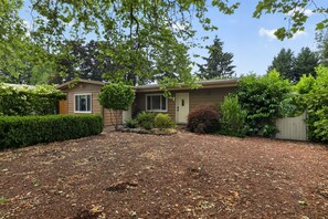 A single-story house with a front yard, a wooden fence, and a variety of shrubs and trees. - PNW Oasis w/PVT Ste. nr Nike/Intel-Pet Friendly (Aloha)