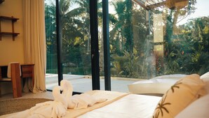 A hotel room with a bed, a window, and a view of greenery. - Dzen Sari Ubud Villa! Rice fields, pool and Stone bath! (Kabupaten Gianyar)