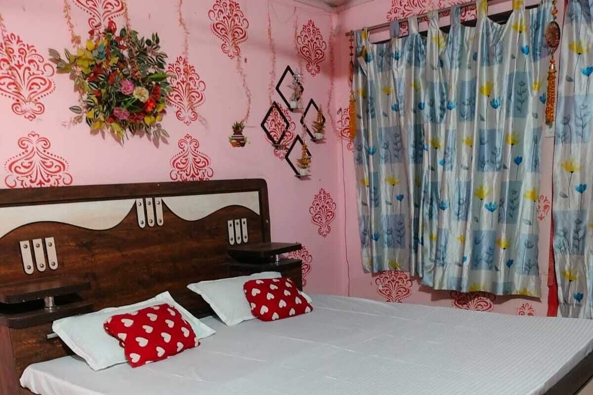 A bedroom with a wooden bed, white bedding, and floral wall decorations.