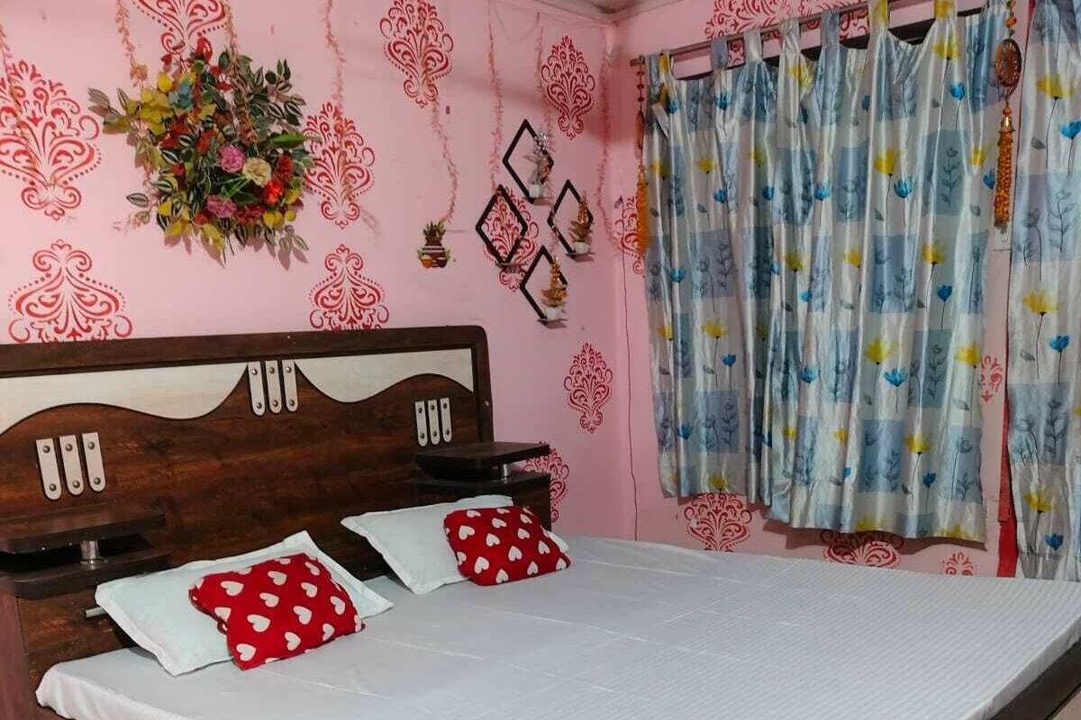 A bedroom with a wooden bed, white bedding, and floral wall decorations.