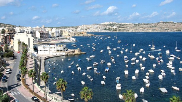 A coastal cityscape with a marina filled with boats, buildings along the waterfront, and a clear sky. - 2BR Maisonette Near St. Paul`s Bay & Beaches (St. Paul`s Bay)