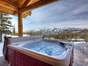 A hot tub with a wooden roof, surrounded by snow-covered mountains and trees. - New to VRBO - Cowboy Heaven Cabin, Yellowstone Country, Hot Tub, Amazing Views! (Big Sky)