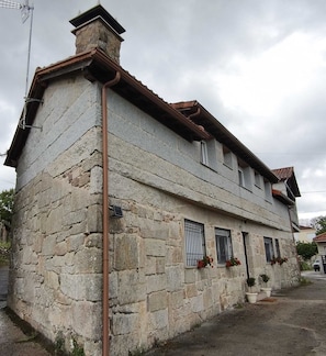 Un bâtiment en pierre doté d’un toit en pente, de nombreuses fenêtres et d’une cheminée bien visible.