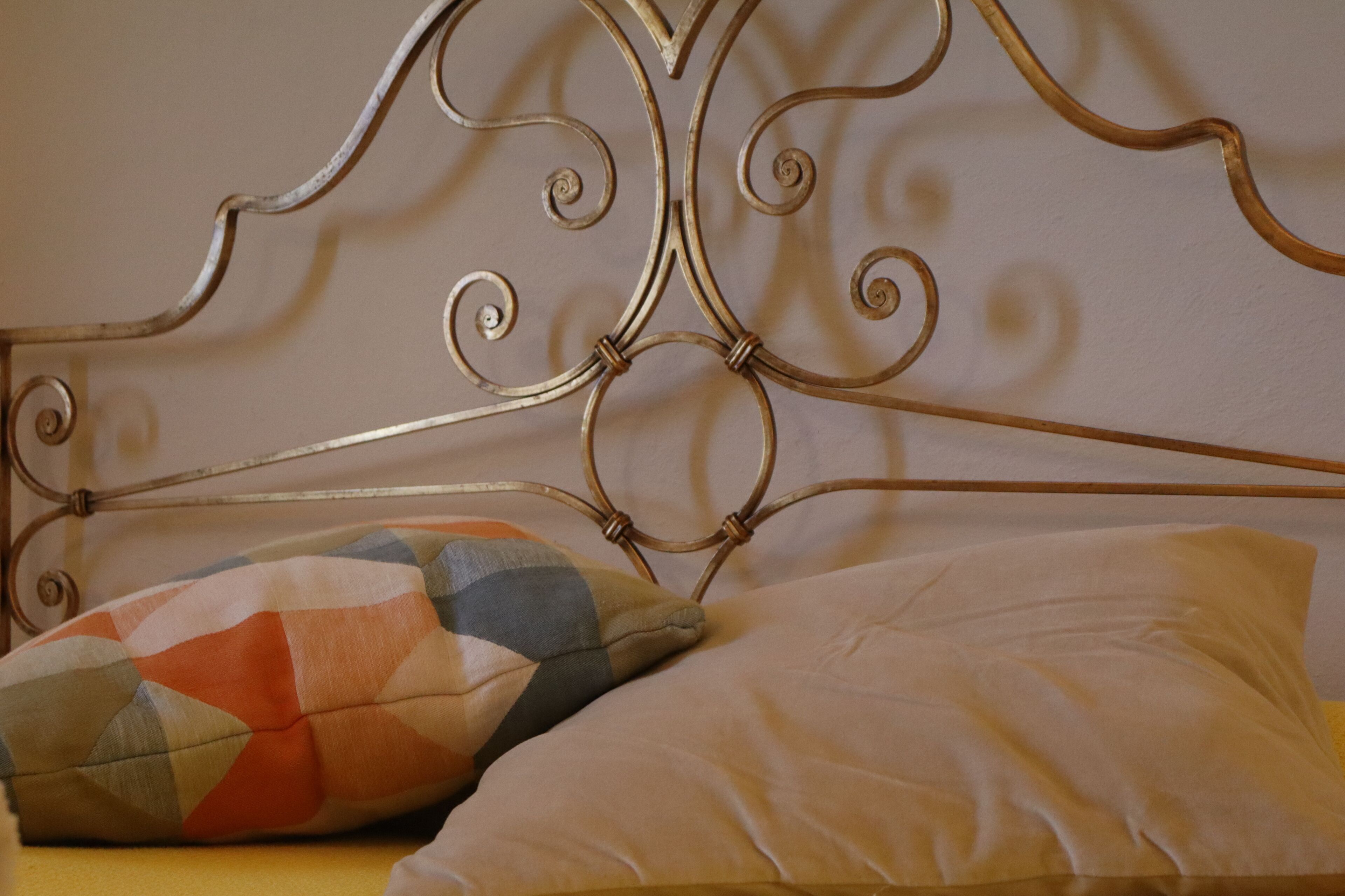 A bed with a metal headboard and two pillows.