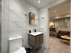 Une salle de bain moderne avec des toilettes, un lavabo et un miroir.