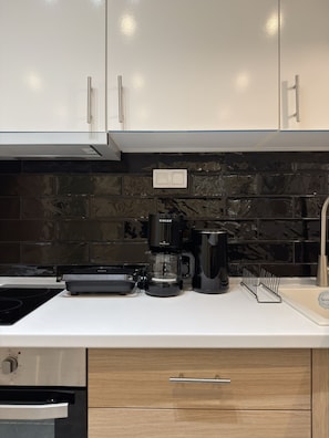 A modern kitchen with a built-in stove, a coffee maker, and a sink. - SmartLiving Central Apt 2 (Thessaloniki)