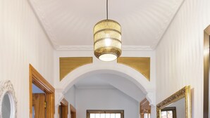 A hallway with wooden doors, a white vase, a mirror, and a ceiling light fixture. - LODGING IN TORRIJOS TOLEDO ALOJAMIENTO TURISTICO DON PEDRO TOLEDO (Torrijos)