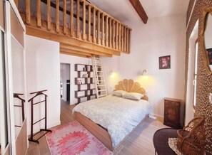 A bedroom with a loft bed, a ladder, a bookshelf, a small cabinet, and a chair. - Vrbo Property (La Ciotat)