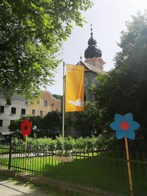 A building with a dome, a yellow flag, and a blue flower-shaped sign.