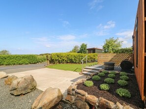 A residential driveway with a concrete path, stone border, and small shrubs. - Alken The Stag (Bushmills)