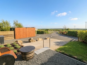 A landscaped outdoor area with a gravel path, wooden deck, and a small shed. - Alken The Stag (Bushmills)