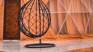 A tent with a logo and text 'Rum mars luxury sands camp' and a hanging chair in front. - Rum mars sands luxury camp (Wadi Rum)