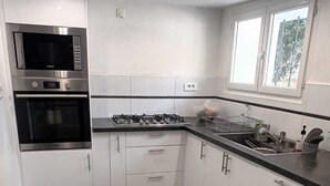 Una cucina moderna dotata di microonde, forno, piano cottura a gas e una finestra.