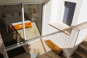 A bedroom with a bed, a window, and a small wooden bench. - Charm & Relaxation: Family Home with Heated Pool (Jard-sur-Mer)