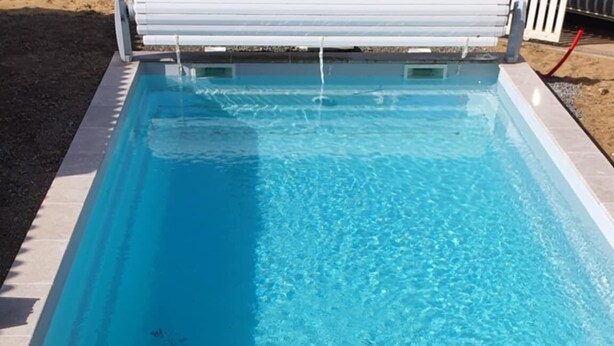 A rectangular swimming pool with a wooden deck and a tiled border. - Charm & Relaxation : Family home with heated pool (Jard-sur-Mer)