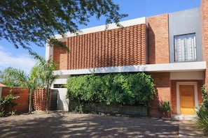 Un bâtiment moderne à deux étages, doté d’une façade en briques, d’une grande fenêtre à l’étage supérieur et d’une entrée abritée.