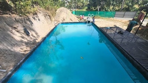 Una piscina rectangular con un deck de madera alrededor.