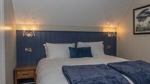 A bedroom with a bed, bedside tables, wall-mounted lights, and a framed picture. - Narrow Water Lodges (Dundalk)