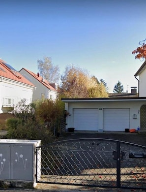 Et boligområde med huse, en garage og et pigtrådshegn.