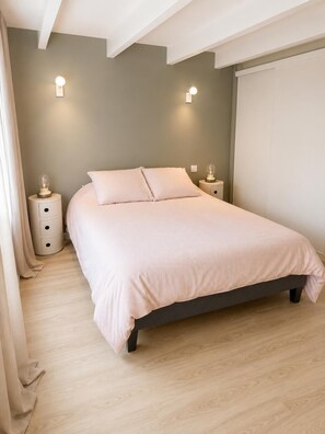 Een slaapkamer met een bed, nachtkastjes en wandlampen.