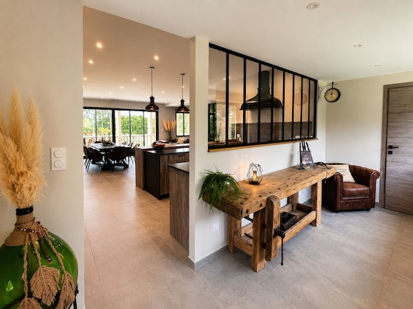 A modern kitchen with a large island, pendant lighting, and a view to the outdoors. - Le Chesterfield - 4 suites with private Jacuzzi at Domaine de Giverzac (Domme)