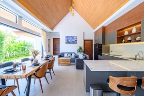 A modern kitchen with a large island, wooden ceiling, and a dining area with a table and chairs. - Belle Vie Villa – Stylish Private Pool Retreat in Koh Samui (Bo Put)