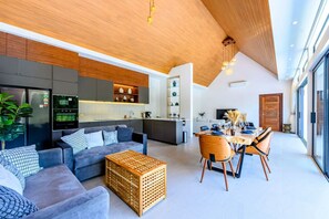 A modern living space with a sofa, dining table, and kitchen area. - Belle Vie Villa – Stylish Private Pool Retreat in Koh Samui (Bo Put)