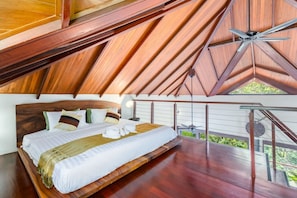 A bedroom with a wooden ceiling, a bed with white bedding, and a view of greenery outside. - Villa Sunset Rock by MPS (Na Mueang)