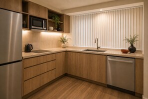Eine moderne Küche mit Holzausstattung, Edelstahlgeräten, einer eingebauten Mikrowelle und einem Fenster mit Jalousien.
